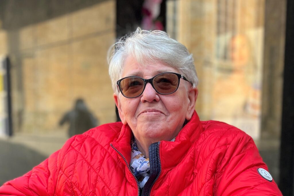 "Oma Jutta" lächelt in die Kamera und trägt eine Sonnenbrille.