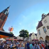 Marktplatz in Haltern bei blauem Himmel mit dem alten Rathaus und der Kirche sowie vielen Menschen und Ständen