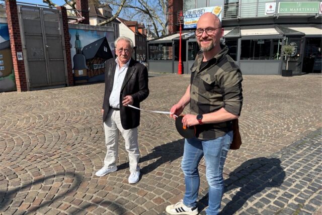 Zwei Männer stehen auf dem Neumarkt und halten ein Maßband.