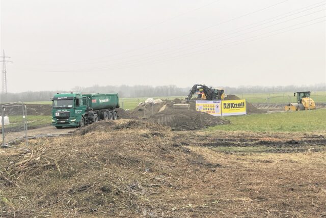 Ein Bagger und ein Lkw arbeiten auf einer Baustelle