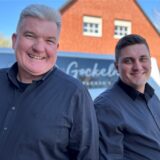 Stefan und Maximilan Gockeln vor dem Firmenlogo (v.l.).