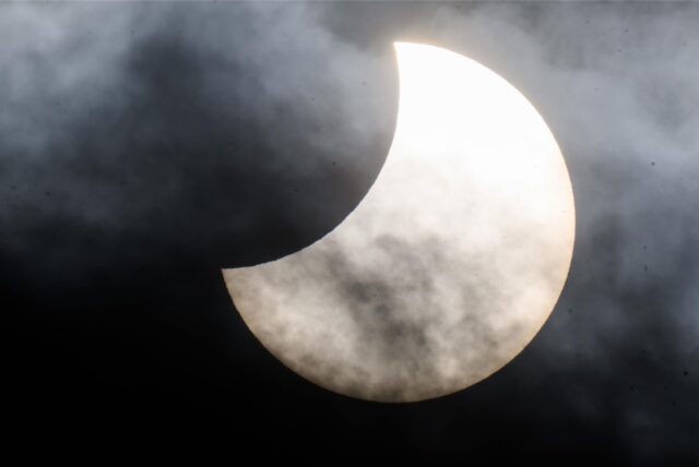 Während einer partiellen Sonnenfinsternis schiebt sich der Mond teilweise zwischen Sonne und Erde.
