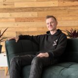 Tätowierer Patric Krakau auf dem Sofa seines Studios, Kaiserstraße 68 in Herten.