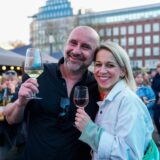 Zwei Besucher halten beim ersten Feierabendmarkt 2025 in Dortmund ein Glas Wein in der Hand.