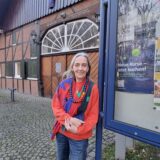 VHS-Leiterin Rosemarie Schloßer steht vor dem Dorfschultenhof.