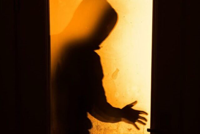 Eine menschliche Person steht vor einem Fenster. Es ist nur der Schatten zu sehen.