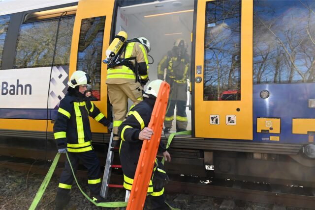 Feuerwehrleute verschaffen sich Zugang zu einem Zug.