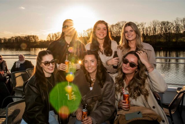 Sechs Frauen mit Getränken bei Sonnenuntergang auf der Möwe