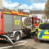 Feuerwehr und Polizei stehen auf der Tiefe Straße in Dortmund wegen eines Wohnungsbrandes.