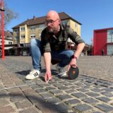 Zwei Männer stehen auf dem Neumarkt in Datteln und halten ein Maßband.