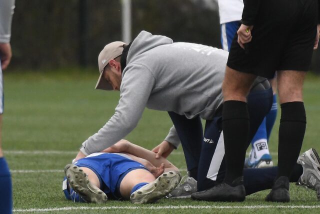 Ein Spieler des FC Castrop-Rauxel (weiß) verletzt sich im Derby gegen die BG Schwerin. Der Status ist noch unbekannt.