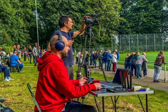 Manuel Hill filmt ein Fußballspiel, Eleftherios Zavrakidis Herrero kommentiert es.