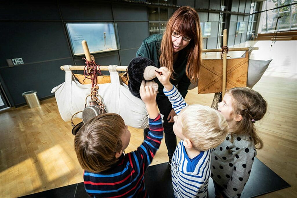 Kinder spielen mit einer Puppe im LWL-Römermuseum in Haltern Kinder spielen mit einer Puppe im LWL-Römermuseum in Haltern