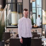 Ein Koch des Dortmunder Restaurants Haus Phönixsee steht im mit einem Teller Essen im Gastraum