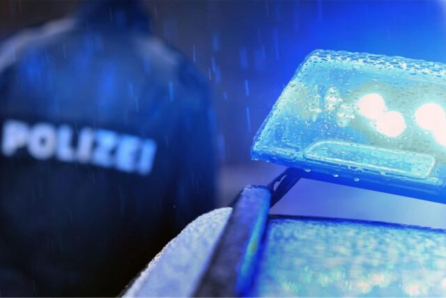 Das Blaulicht eines Polizeiautos im Regen.