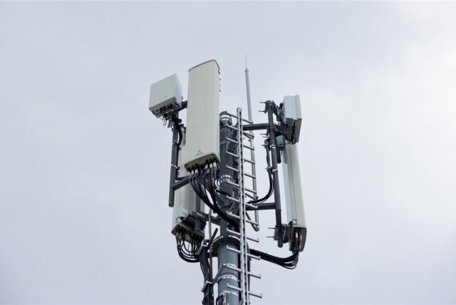 Ein Mobilfunksendemast mit Mobilfunkantennen für LTE (länglich) und 5G (quadratisch) steht auf dem Dach eines Hauses.