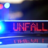 Symbolbild einer leuchtenden Unfallschrift auf einem Polizeiauto.