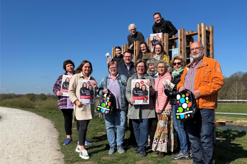 Anke Klapsing-Reich und die anwesenden lokalen Partner halten Plakate in der Hand und stehen an der Lippe Lese Lounge in Dorsten.