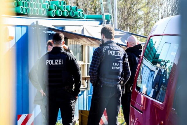 Polizeibeamte und LKA-Mitarbeiter stehen auf dem Betriebsgelände einer Kiesgrube. Diese wurde bei einem Einsatz wegen des Verdachts schwerwiegender Umweltstraftaten durchsucht. Etwa 300 Kräfte von Polizei und Staatsanwaltschaft sind in Nordrhein-Westfalen dabei im Einsatz. Dazu gehörten Angehörige des Landeskriminalamts, der Polizei NRW und der Zentralstelle für die Verfolgung der Umweltkriminalität in Dortmund. Mehr als 50 Durchsuchungsbeschlüsse in Nordrhein-Westfalen würden vollstreckt.