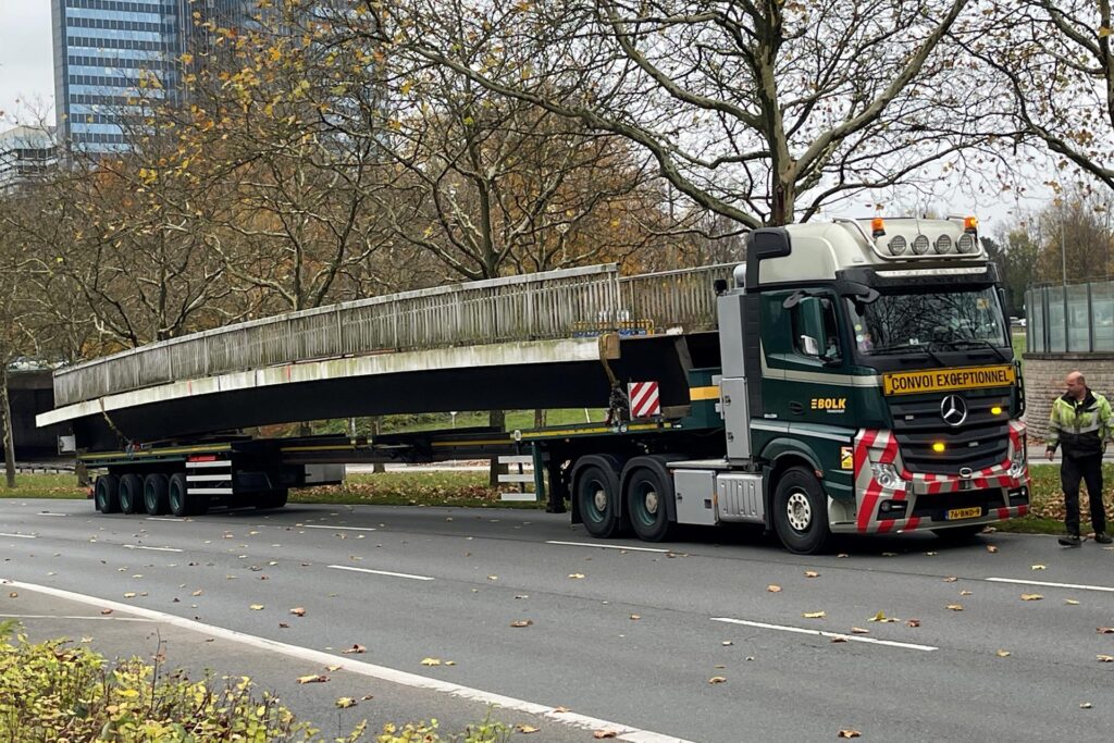 Ein Teil einer Fußgängerbrücke liegt auf einem Lastwagen. Ein Teil einer Fußgängerbrücke liegt auf einem Lastwagen.