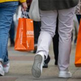 Menschen mit vollen Einkaufstaschen gehen am verkaufsoffenen Sonntag shoppen.
