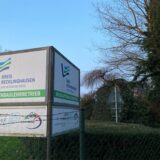 Ein Kubus steht auf einer Wiese.