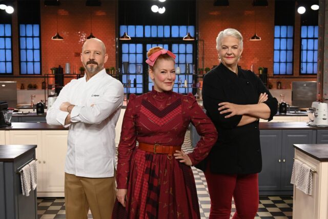 Christian Hümbs (Jury), Enie van de Meiklokjes (Moderatorin) und Bettina Schliephake-Burchardt (Jury) stehen in der Kulisse von „Das große Promibacken 2025“.