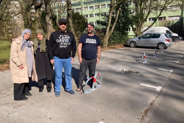 Vier Anwohner der Pommernstraße in Marl stehen vor einem abgesperrten Parkplatz.