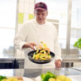 Ingo Grottke von Rebional steht in der Großküche in Herdecke und schwenkt eine Pfanne mit buntem Gemüse.