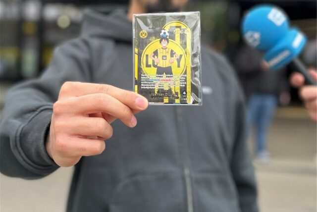 Person zeigt BVB One Piece Karte in die Kamera.