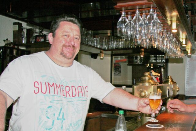 Wirt Stefan Altstadt reicht in seiner Kneipe „Linnertschänke“ ein Bier über den Tresen.