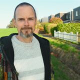 Heiko Friedrich aus Dortmund-Lichtendorf steht zwischen einem Feld und einer Häuserreihe. Er hat eine Selbsthilfegruppe für Adoptierte aus Dortmund und dem Kreis Unna gegründet.