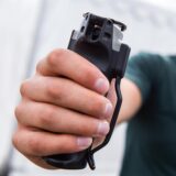Ein Mann hält eine Dose Pfefferspray in der Hand.