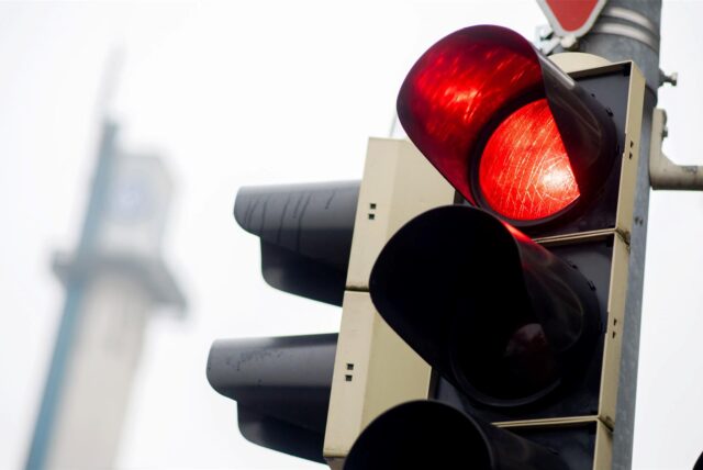 Eine rote Ampel leuchtet an einer Kreuzung im Stadtgebiet