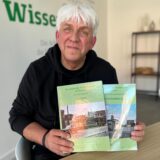 Franz Josef Hauke hält zwei Bücher in der Hand.