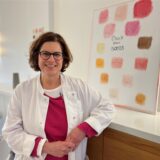 Die neue Leiterin des Brustzentrums in Dorsten Dr. med. Kathrin Sawatzki steht vor einem Bild auf dem steht Check your Boobs (zu Deutsch: überprüfe deine Brüste)