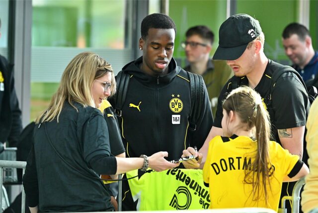 Jamie Gittens und Julian Brandt schreiben Autogramme.
