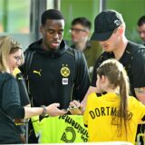 Jamie Gittens und Julian Brandt schreiben Autogramme.
