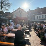 Menschen sitzen am Halterner Marktplatz im Sonnenschein
