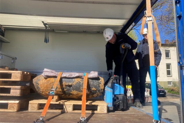 Zwei Mitarbeiter des Kampfmittelbeseitigungsdienstes der Bezirksregierung verladen die gefundene 500-Kilo-Bombe.