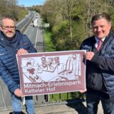 Christian Wessels (links) vom Ketteler Hof und Andreas Stegemann zeigen ein neues Hinweisschild.
