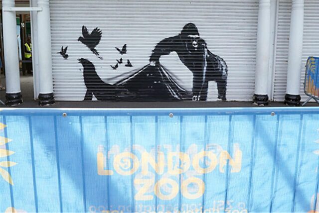 Das Kunstwerk von Banksy am Londoner Zoo zeigt das Bild eines Gorillas auf einem Rollladen, der einen Rollladen hochhebt, sodass Vögel und ein Seehund entkommen, während drei Augenpaare anderer Tiere in der Dunkelheit zu sehen sin