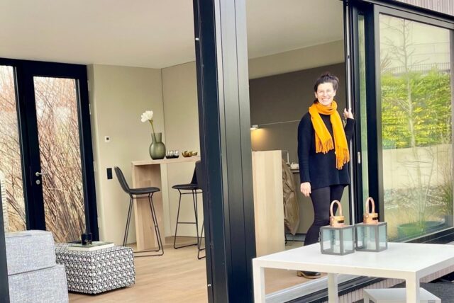Eine Frau steht im Eingang eines Tiny-Houses.