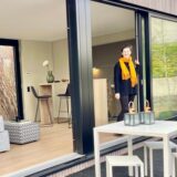 Eine Frau steht im Eingang eines Tiny-Houses.