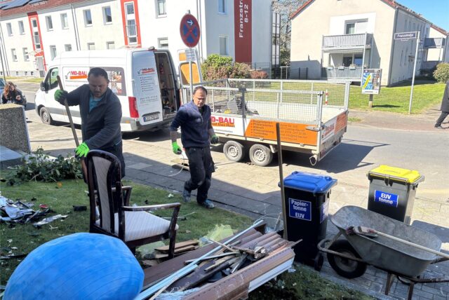 Am Tag nach dem Unfall räumen Mitarbeiter im Vorgarten Trümmer ein und laden sie auf einen Anhänger.