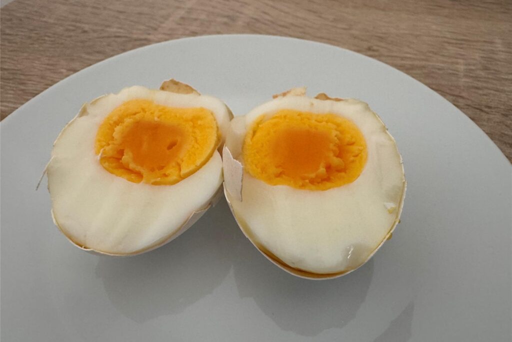Ein in zwei Hälften geteiltes, hartgekochtes Ei, das im Airfryer gegart wurde. Ein in zwei Hälften geteiltes, hartgekochtes Ei, das im Airfryer gegart wurde.