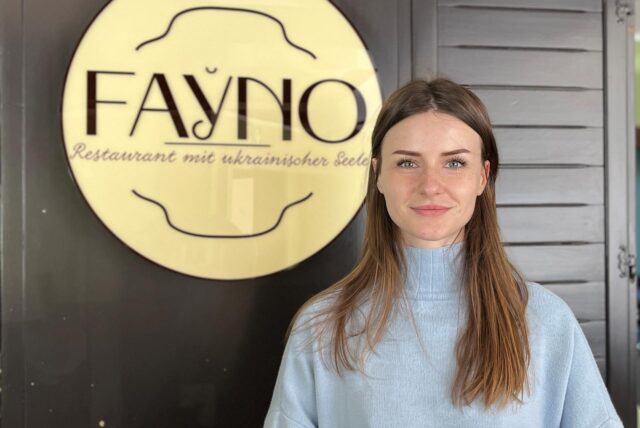 Valeria Humeniuk steht vor ihrem Restaurant-Logo.