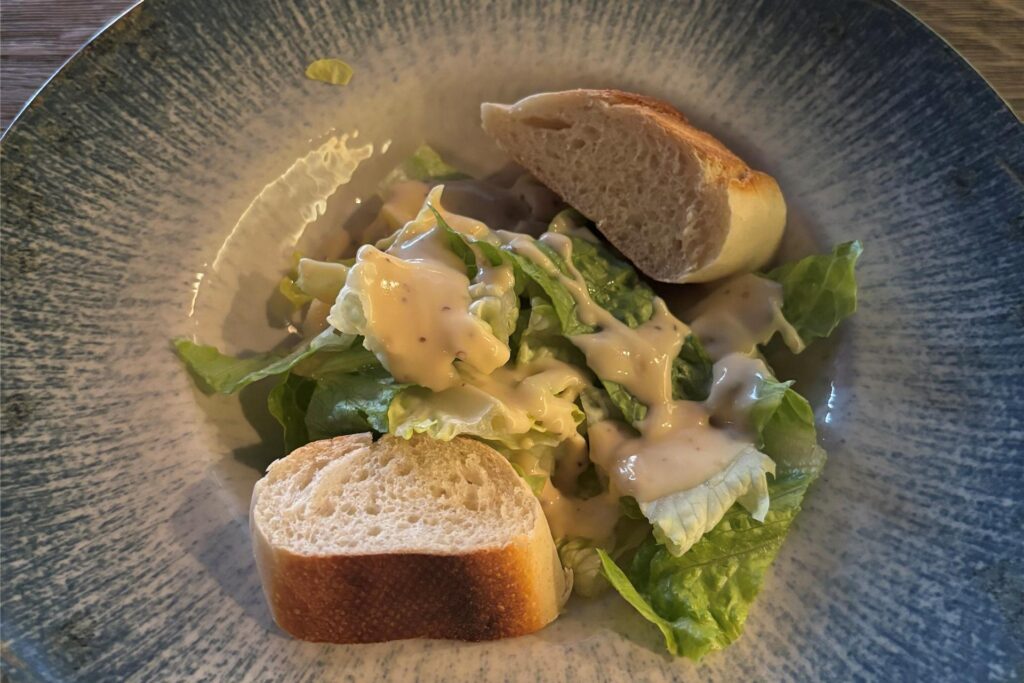 Ein grüner Salat mit Honig-Senf-Soße und Baguettescheiben im Wamo in Dortmund.