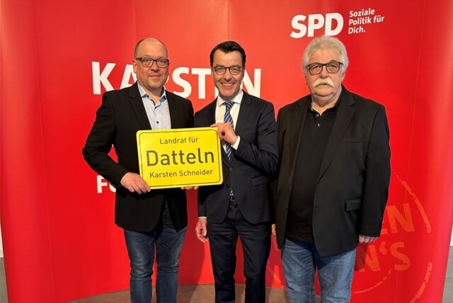 Falco Böhlje, Dr. Karsten Schneider und Hans Peter Müller stehen für einem SPD-Plakat.