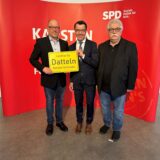 Falco Böhlje, Dr. Karsten Schneider und Hans Peter Müller stehen für einem SPD-Plakat.